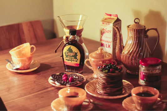 Breakfast on wooden table with Maple Syrup next to cookies